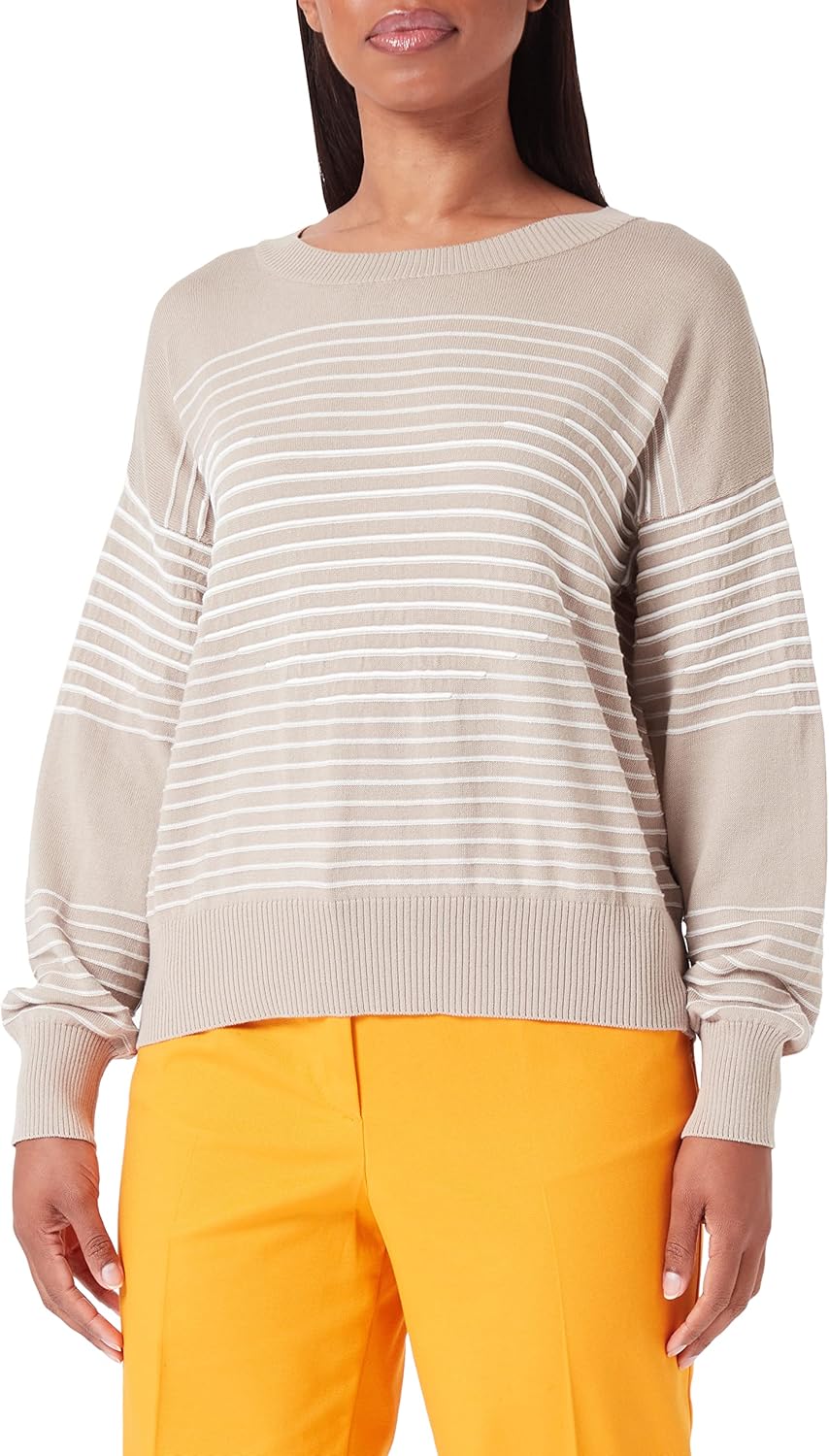'Maglione Benetton donna in cotone beige indossato in un ambiente casual'